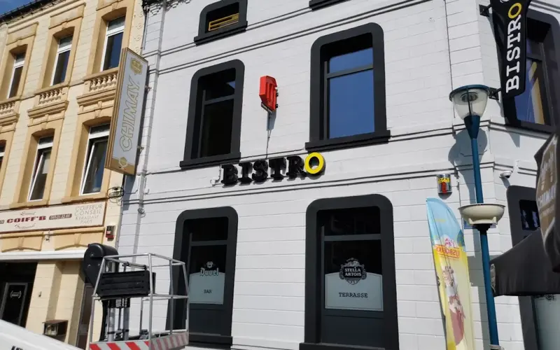 Le mot BISTRO sur la façade blanche, avec le O jaune
