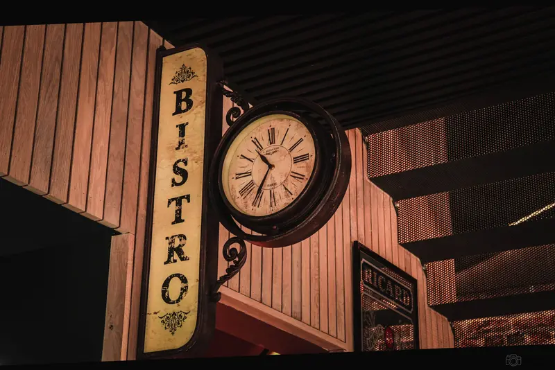 Enseigne BISTRO verticale et horloge ancienne à l’intérieur